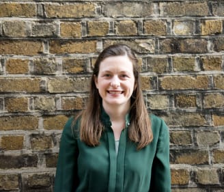 Headshot of Kate Mannion, Irish Refugee Council Law Centre Managing Solicitor standing in front of a brick wall